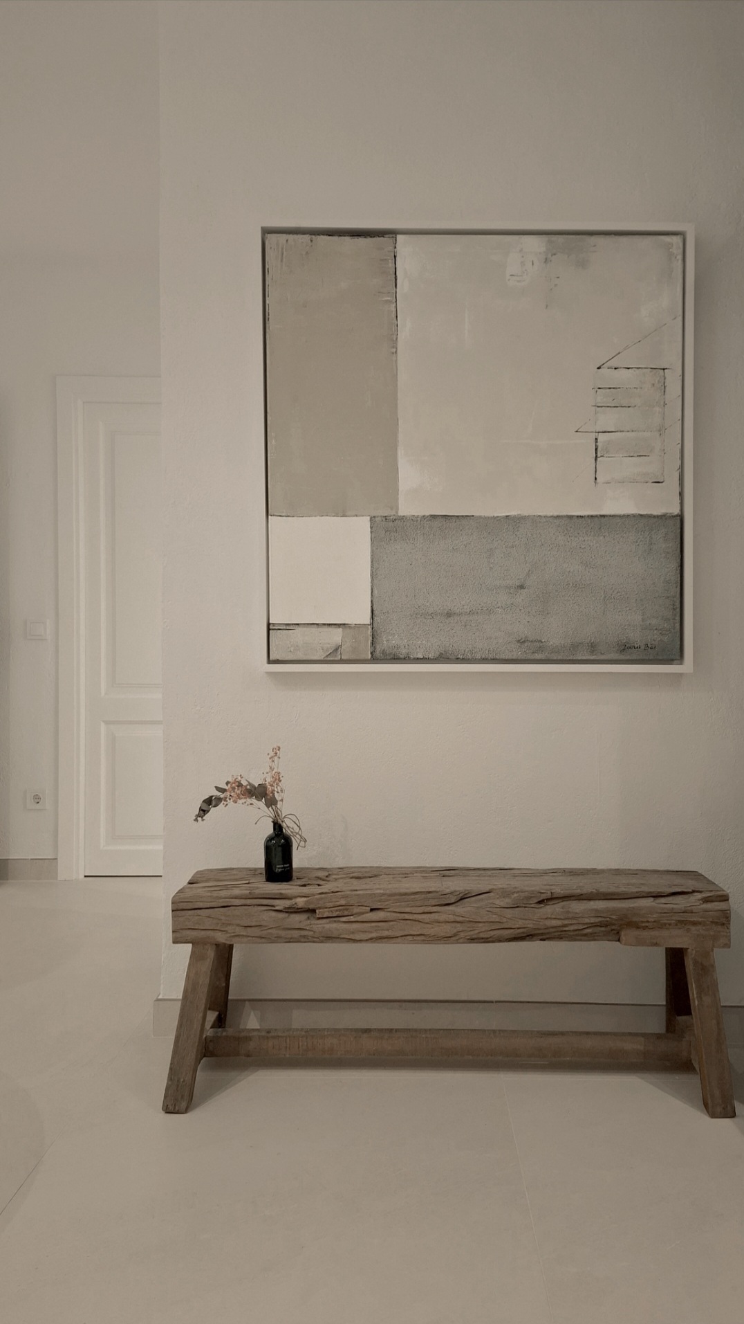 Neutral textured acrylic artwork above solid wood bench in minimalist interior