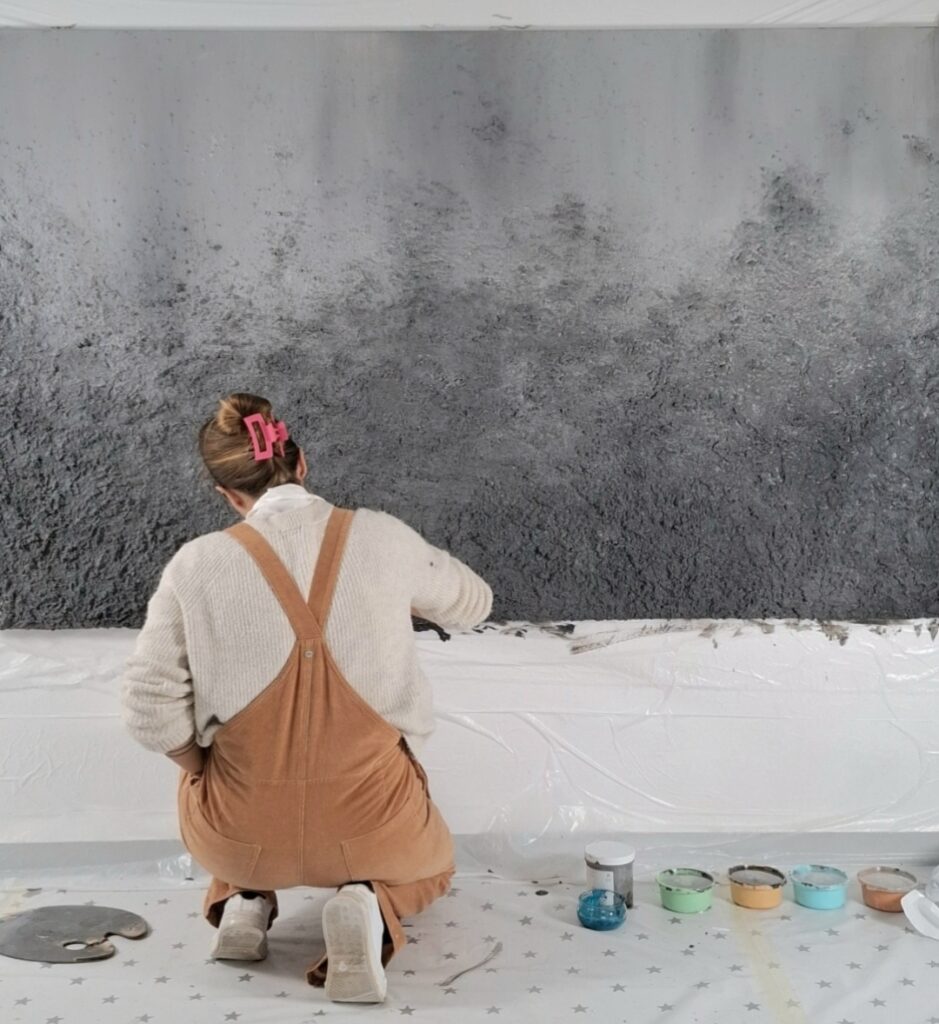 Janis Baer working on a large textured acrylic canvas in her Mallorca studio